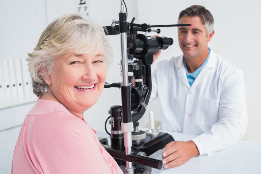 Smiling lady at the eye doctor. Click to learn about vision and dental insurance.